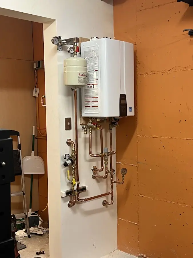 Plumbing technician inspecting water heater connections in Delmar
